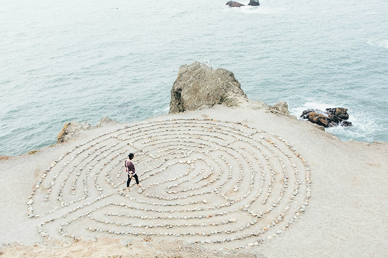 Photo d'une personne vue de haut cherchant son chemin dans un labyrinthe de galets