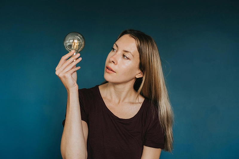 Photo d'une femme tenant une ampoule dans sa main