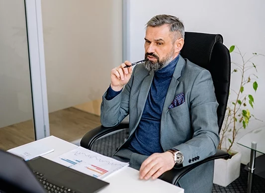 Photo d'un homme professionnel à son bureau qui se pose des questions